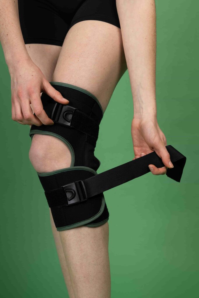 Gros plan sur une attelle de genou Gekomed avec sangles de serrage ajustables et maintien compressif autour du genou.